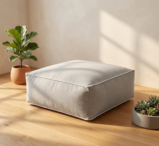 Grand coussin de sol carré de style zafu pour la méditation, en tissu de lin et coton de couleur beige naturel, posé dans un espace épuré.