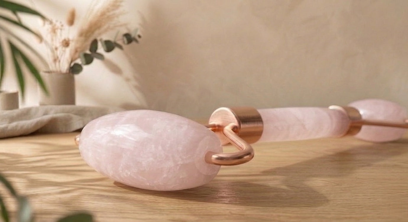 Rouleau de massage facial double embout en pierre fine naturelle de quartz rose avec une poignée ergonomique pour le drainage du visage.