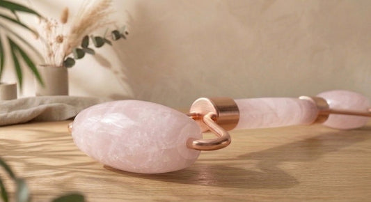 Rouleau de massage facial double embout en pierre fine naturelle de quartz rose avec une poignée ergonomique pour le drainage du visage.