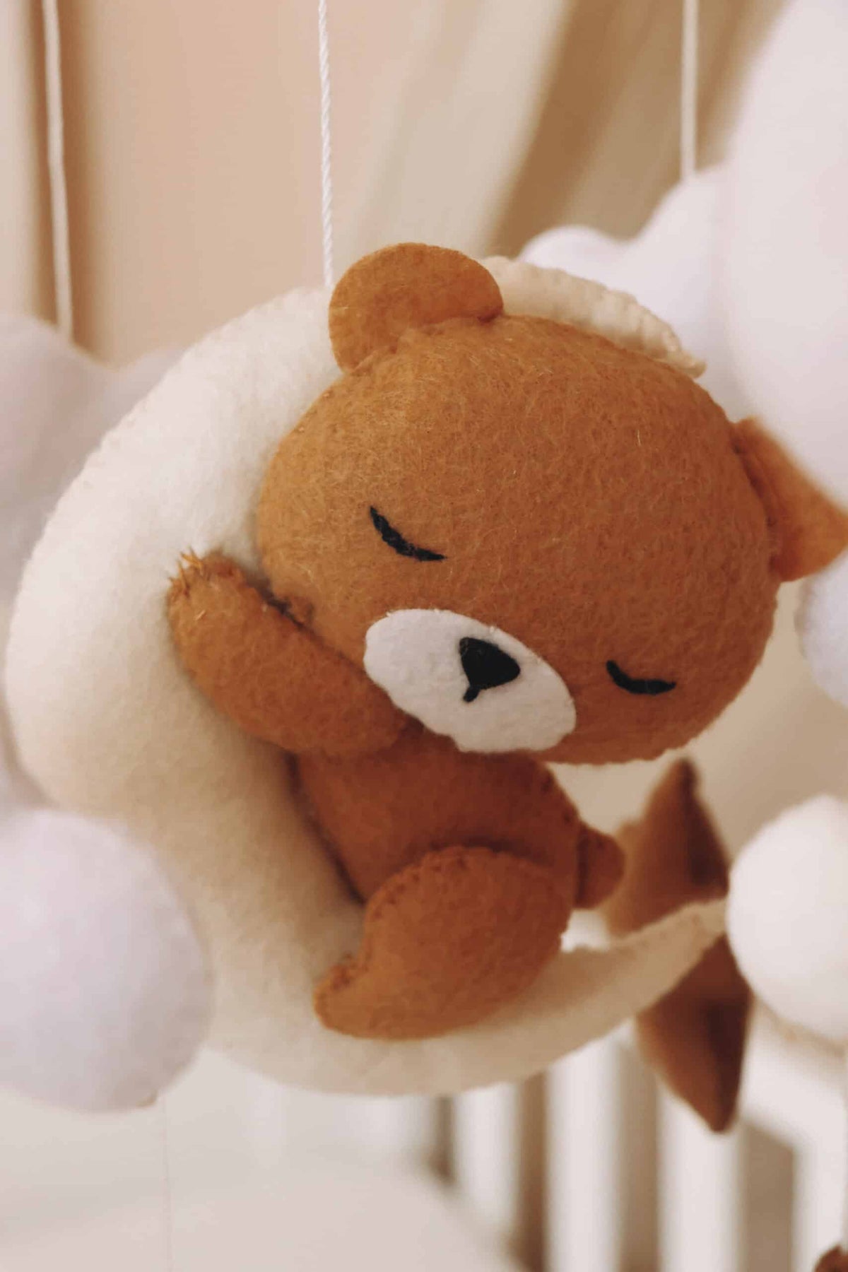 petit ours brun endormi sur une lune blanche en peluche