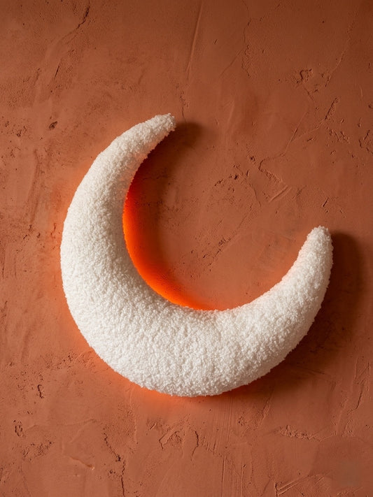 Veilleuse murale pour enfant en forme de croissant de lune en tissu bouclé blanc cassé texturé, diffusant une lumière douce en arrière-plan