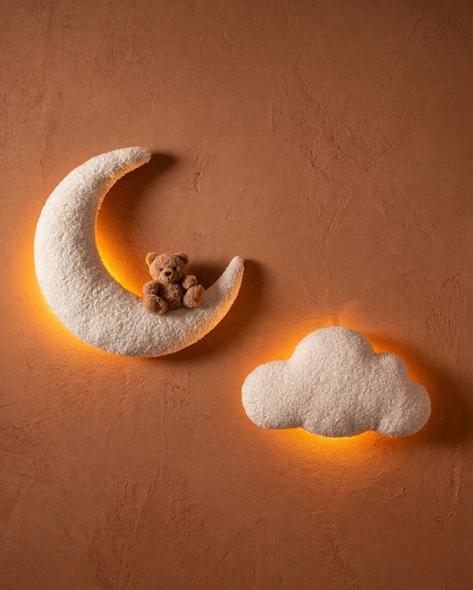 Duo de décorations murales pour chambre d'enfant composé d'un petit ourson brun assis sur une demi-lune blanche, d'un nuage, le tout confectionné en tissu bouclé doux et chaleureux.