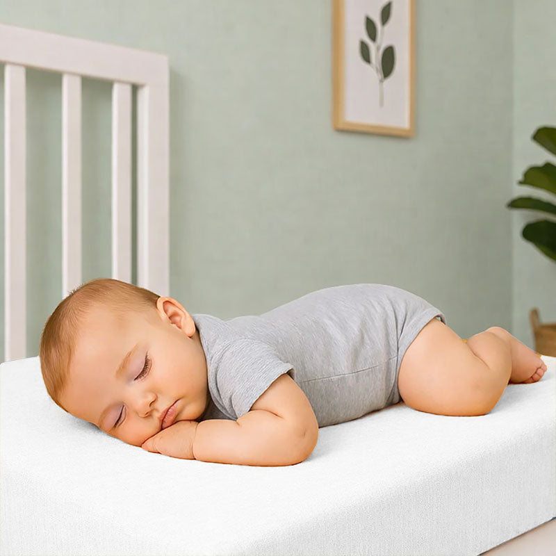 Drap housse pour lit de bébé en double gaze de coton biologique blanc, posé à plat et révélant sa texture gaufrée et douce. 60x120