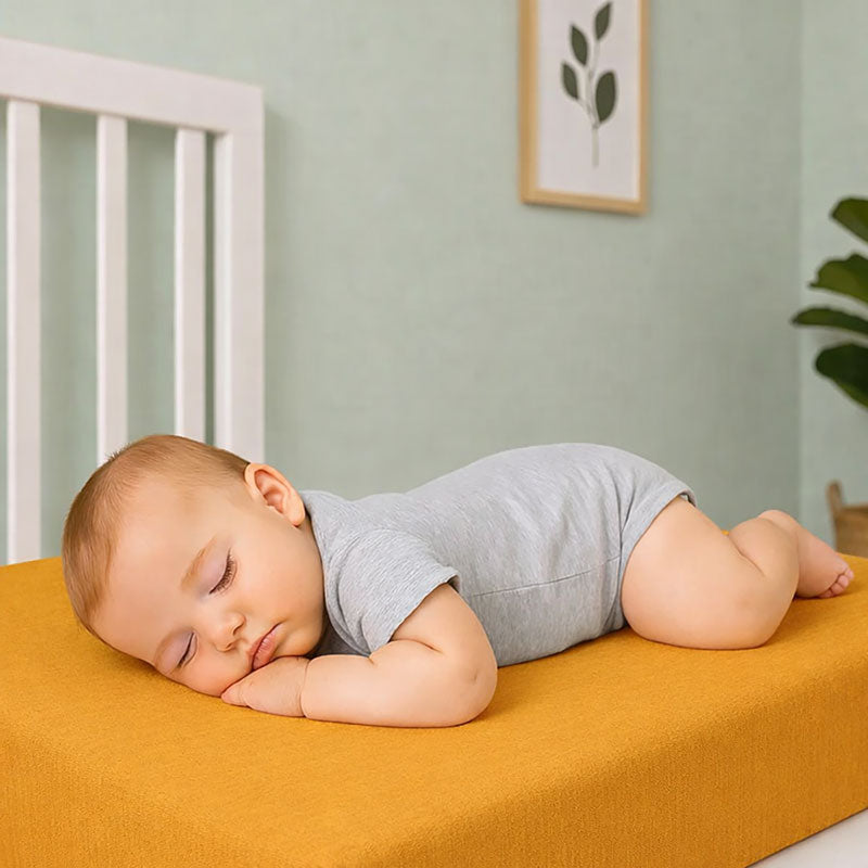 Drap housse pour lit de bébé en double gaze de coton biologique honey, posé à plat et révélant sa texture gaufrée et douce. 60x120