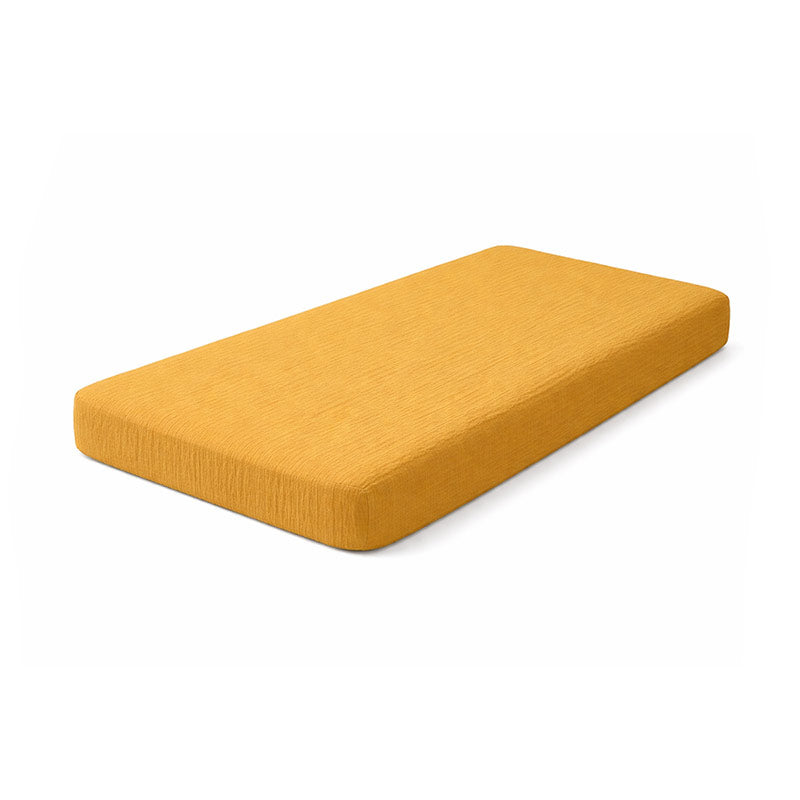 Drap housse pour lit de bébé en double gaze de coton biologique honey, posé à plat et révélant sa texture gaufrée et douce. 60x120