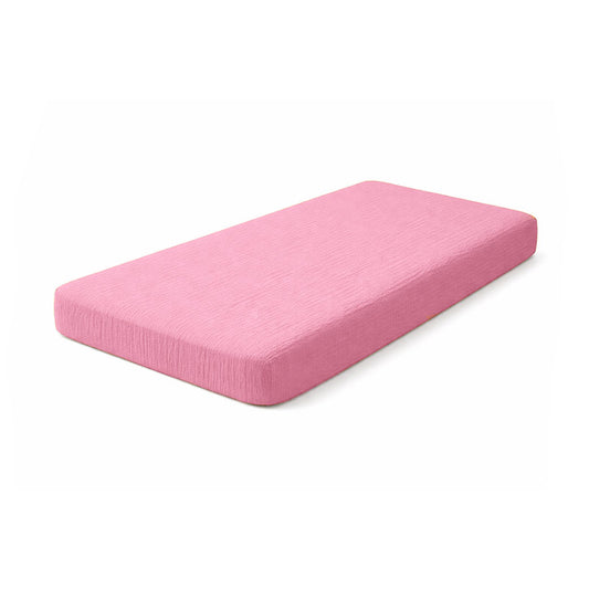 Drap housse pour lit de bébé en double gaze de coton biologique rose, posé à plat et révélant sa texture gaufrée et douce. 60x120