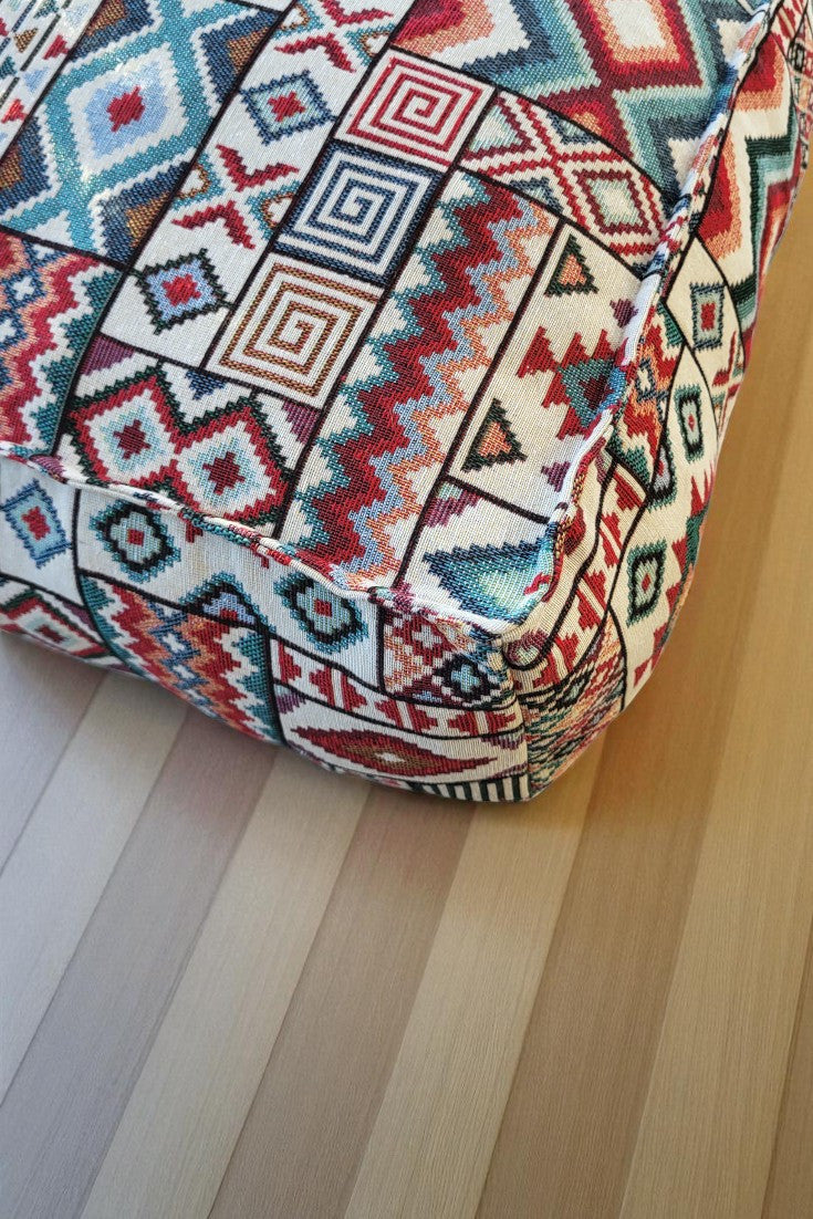 Grand coussin de sol zafu carré modèle Atlas, orné de motifs géométriques ethniques de style kilim aux couleurs rouge, bleu, orange et beige