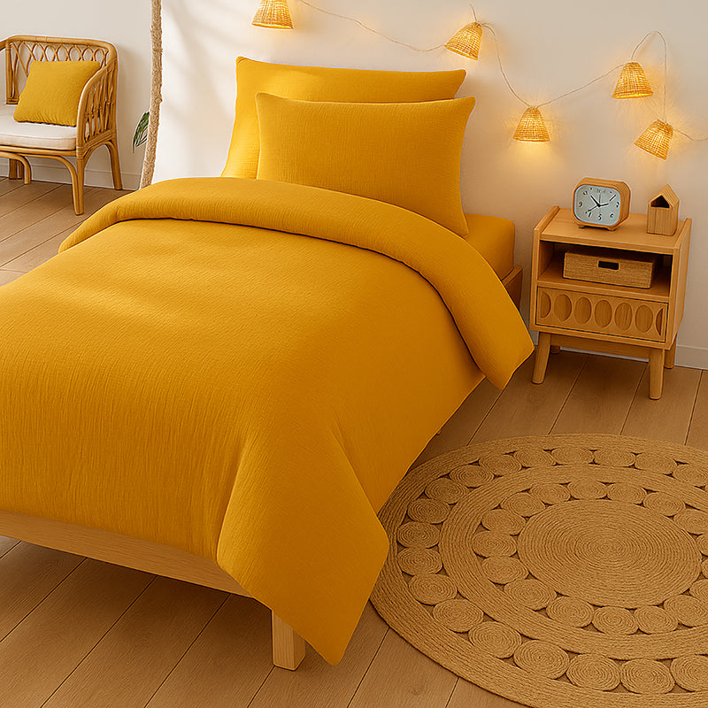 Housse de couette pour lit d'enfant en coton biologique de couleur honey, pliée de manière élégante. coton bihoney papate