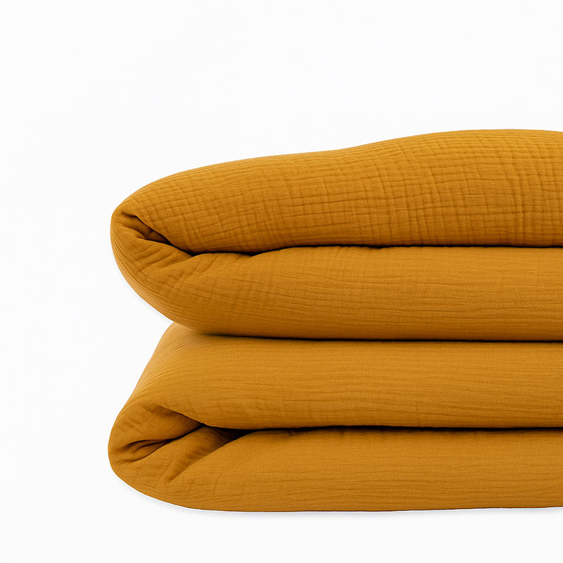Housse de couette pour lit d'enfant en coton biologique de couleur honey, pliée de manière élégante. coton bihoney papate