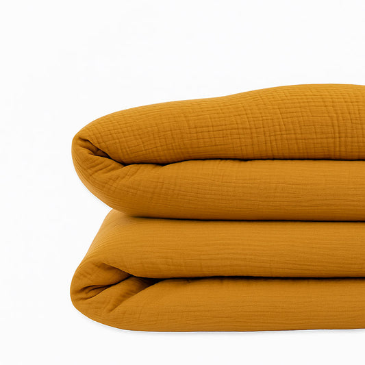 Housse de couette pour lit d'enfant en coton biologique de couleur honey, pliée de manière élégante. coton bihoney papate