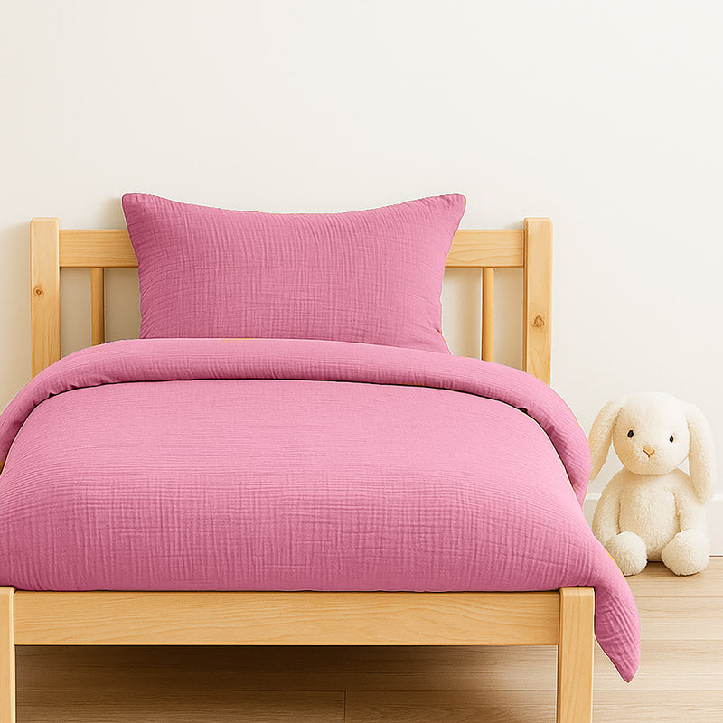 Housse de couette pour lit d'enfant en coton biologique de couleur rose, pliée de manière élégante. coton bio rose papate100x140