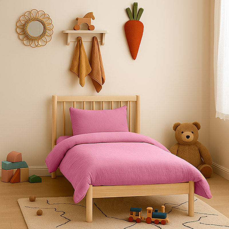 Housse de couette pour lit d'enfant en coton biologique de couleur rose, pliée de manière élégante. coton bio rose papate