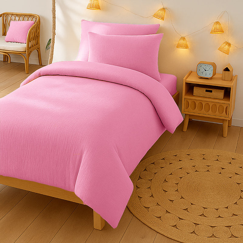 Housse de couette pour lit d'enfant en coton biologique de couleur rose, pliée de manière élégante. coton bio rose papate