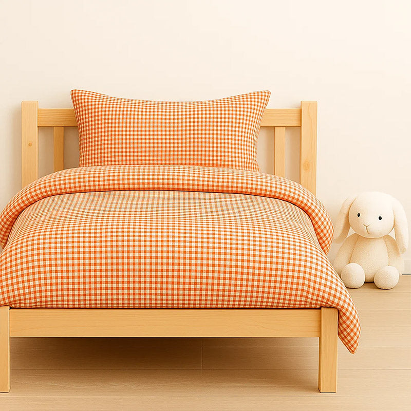 Housse de couette pour lit d'enfant en coton biologique de couleur vichy rouge et blanc, pliée de manière élégante. coton bio vichy papate