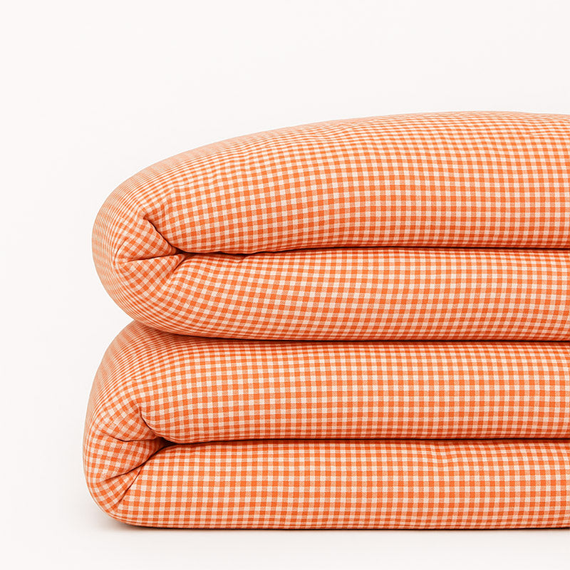 Housse de couette pour lit d'enfant en coton biologique de couleur vichy rouge et blanc, pliée de manière élégante. coton bio vichy papate