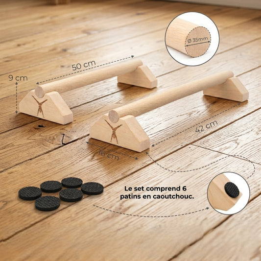 Photo de style de vie : Une paire de mini-paralllettes en bois Maxmoi avec toutes leurs dimensions (50cm, 16cm, 1, 9cm) dans une salle de gym à domicile lumineuse. Le set inclut 6 patins en caoutchouc.