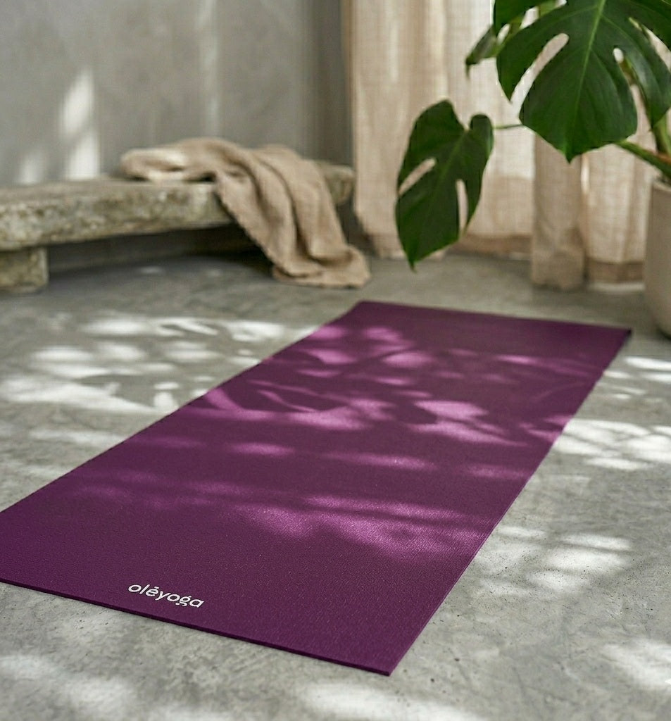 Tapis de yoga violet antidérapant Oléyoga entièrement déroulé dans un espace de pratique zen et épuré.