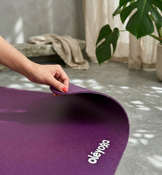 Tapis de yoga violet antidérapant Oléyoga entièrement déroulé dans un espace de pratique zen et épuré.